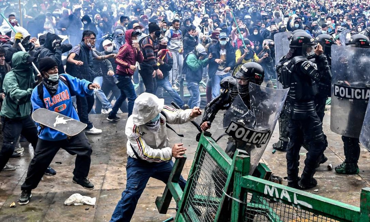 Manifestantes enfrentam tropas de choque durante protesto contra projeto de reforma tributária lançado pelo presidente colombiano Ivan Duque, em Bogotá Foto: Juan Barreto / AFP
