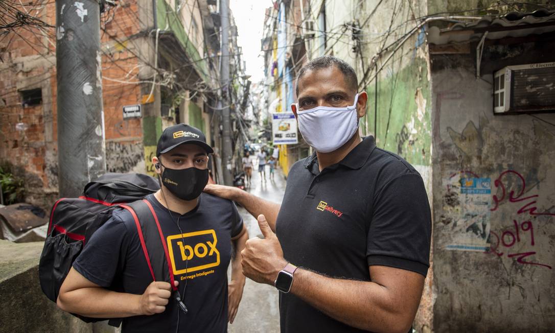 Na Rocinha, no Rio, delivery de comida beneficia trabalhadores como Rômulo Leite e empresas como a de Alexandre Araújo (à direita)
Foto: Ana Branco