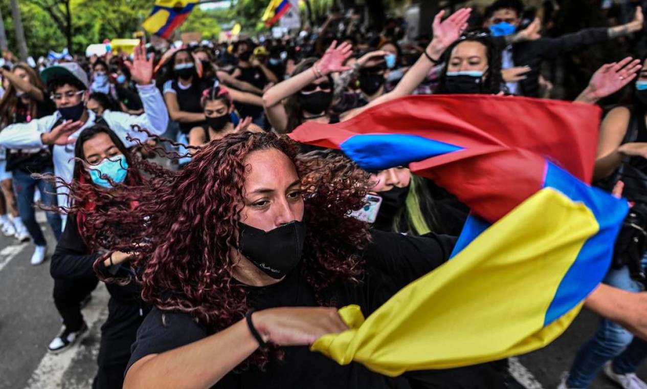 Manifestantes dançam durante um protesto contra um projeto de reforma tributária lançado pelo presidente Ivan Duque, em Medellín, Colômbia| Foto: JOAQUIN SARMIENTO / AFP