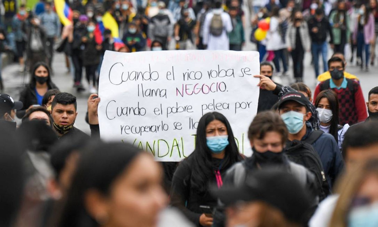 "Quando o rico rouba se chama negócio. Quando o pobre luta para recuperá-lo é chamado de vândalo", diz cartaz de manifestante em Bogotá Foto: JUAN BARRETO / AFP