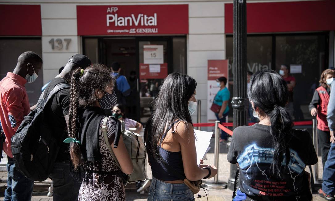 Chilenos fazem fila do lado de fora de uma Administradora de Fundos de Pensão (AFP) em Santiago para fazer a última retirada autorizada pelo Congresso, em abril Foto: MARTIN BERNETTI/26-4-2021 / AFP