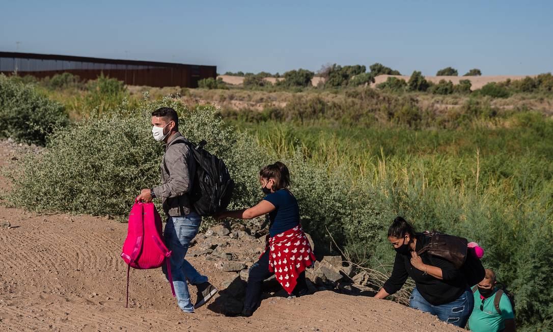 Uma família brasileira atravessa barragem em direção ao muro da fronteira em Yuma, Arizona Foto: ARIANA DREHSLER / NYT