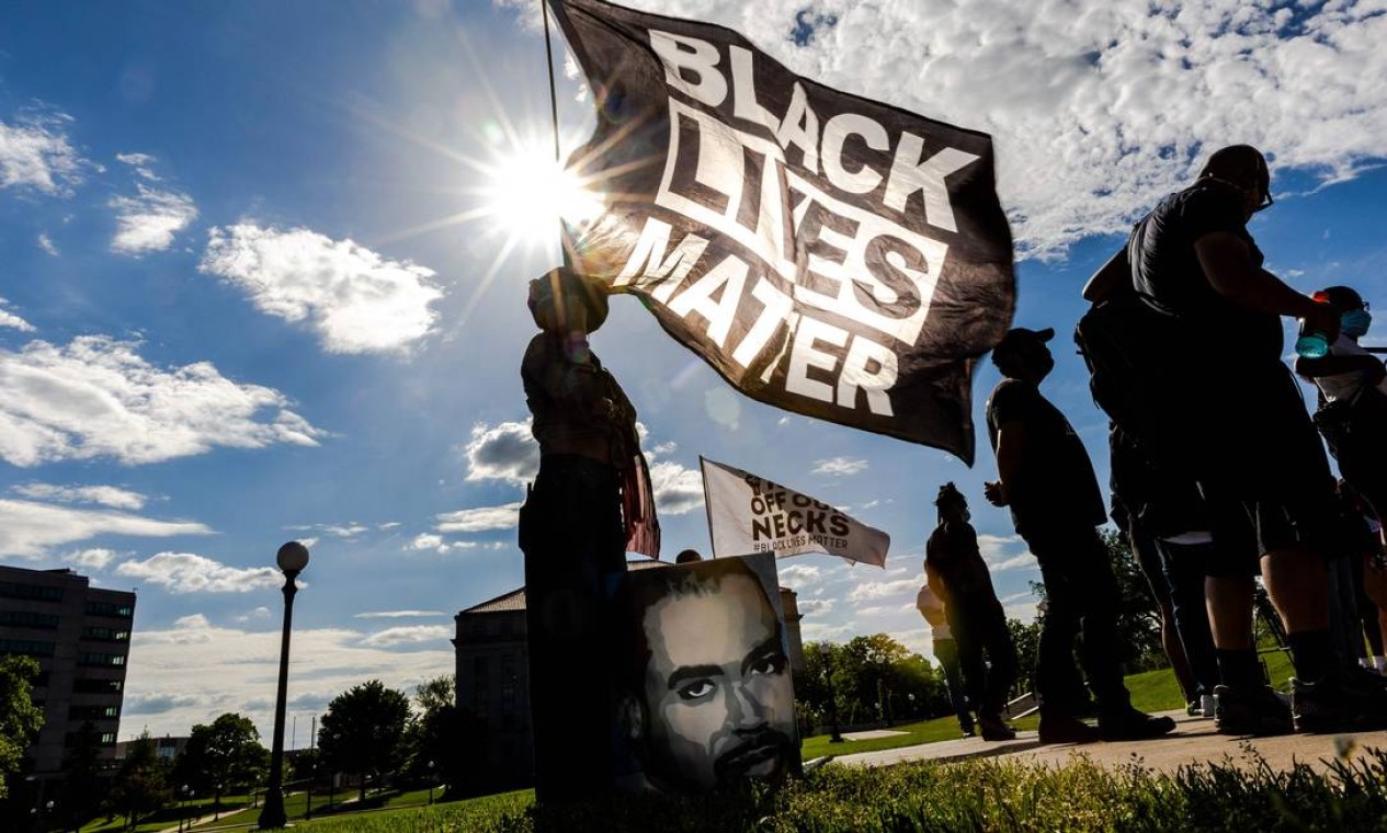 Mulher segura uma bandeira Black Lives Matter durante evento em memória de George Floyd e para pedir justiça para aqueles que perderam entes queridos para a violência policial fora do Capitólio do Estado de Minnesota, no dia em que o assassinato de Floyd completa 1 ano Foto: KEREM YUCEL / AFP