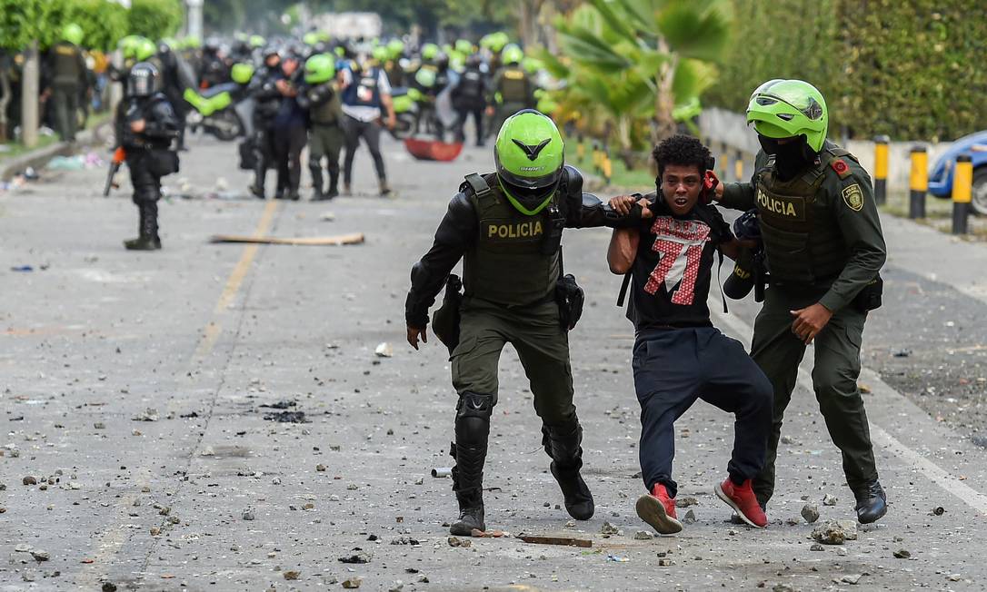 Policiais detêm manifestante durante protesto em Cali, na Colômbia Foto: LUIS ROBAYO / AFP