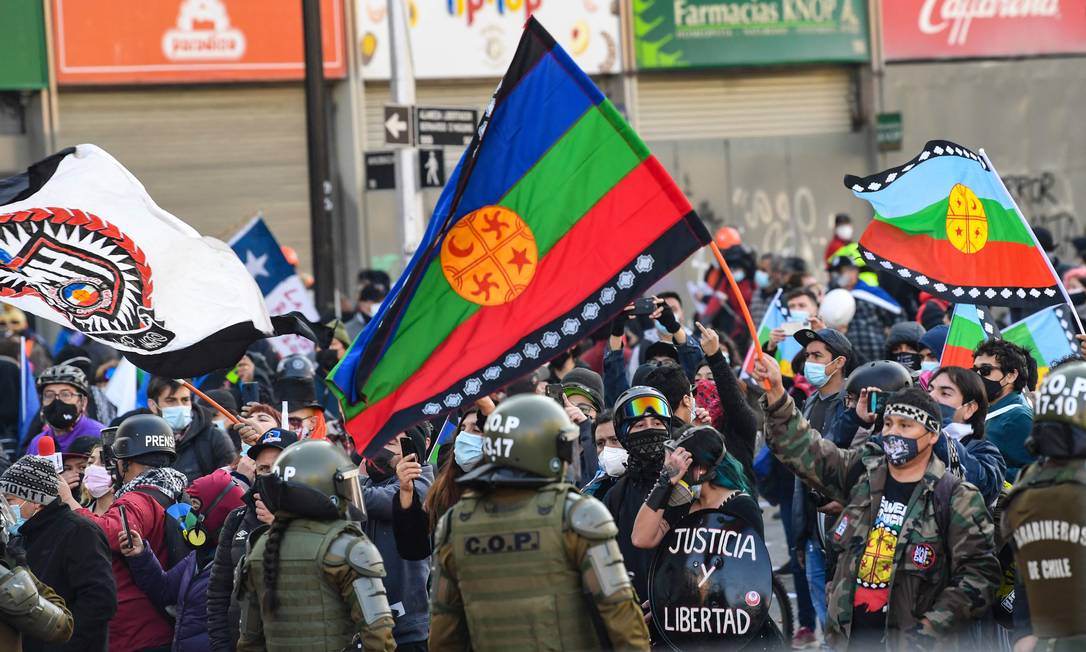 Manifestantes protestam do lado de fora do antigo Congresso onde acontece a sessão inaugural da Convenção Constitucional do Chile Foto: MARTIN BERNETTI / AFP