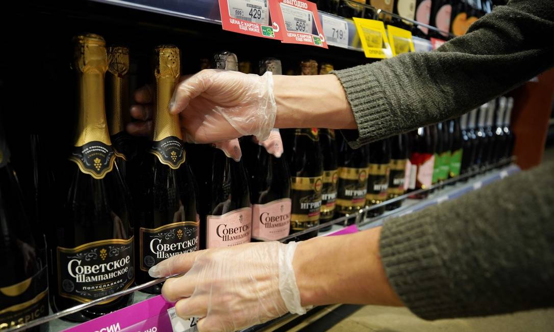 Um funcionário num mercado em Moscou arruma garrafas de vinho na prateleira Foto: TATYANA MAKEYEVA / REUTERS