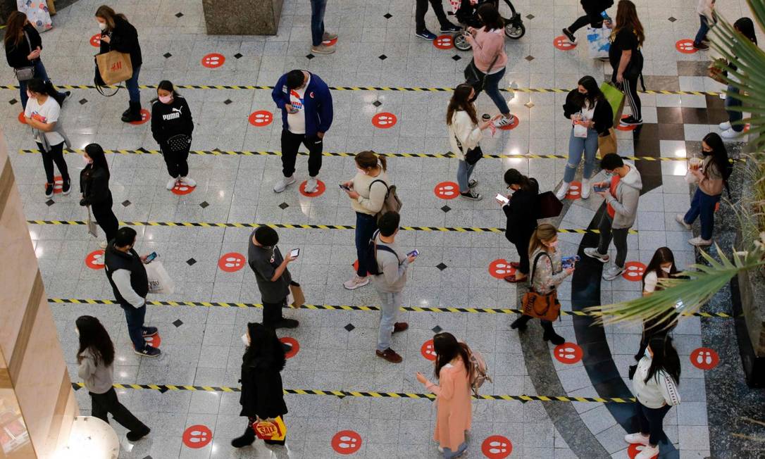 Respeitando o distanciamento, pessoas fazem fila para em praça de alimentação de shopping em Santiago, no Chile Foto: JAVIER TORRES / AFP/19-7-21