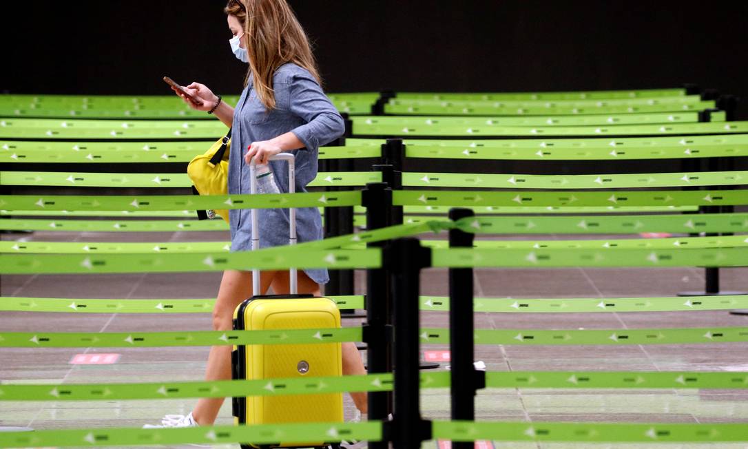 Passageira caminha na área de check-in do Aeroporto de Barcelona, na Espanha Foto: Albert Gea / Reuters