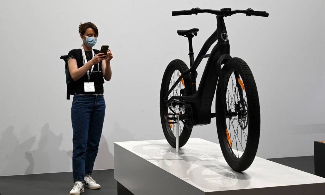 Mulher tira fotos da a Serial 1 eBike da Harley-Davidson que tem sistema de direção Foto: CHRISTOF STACHE/AFP