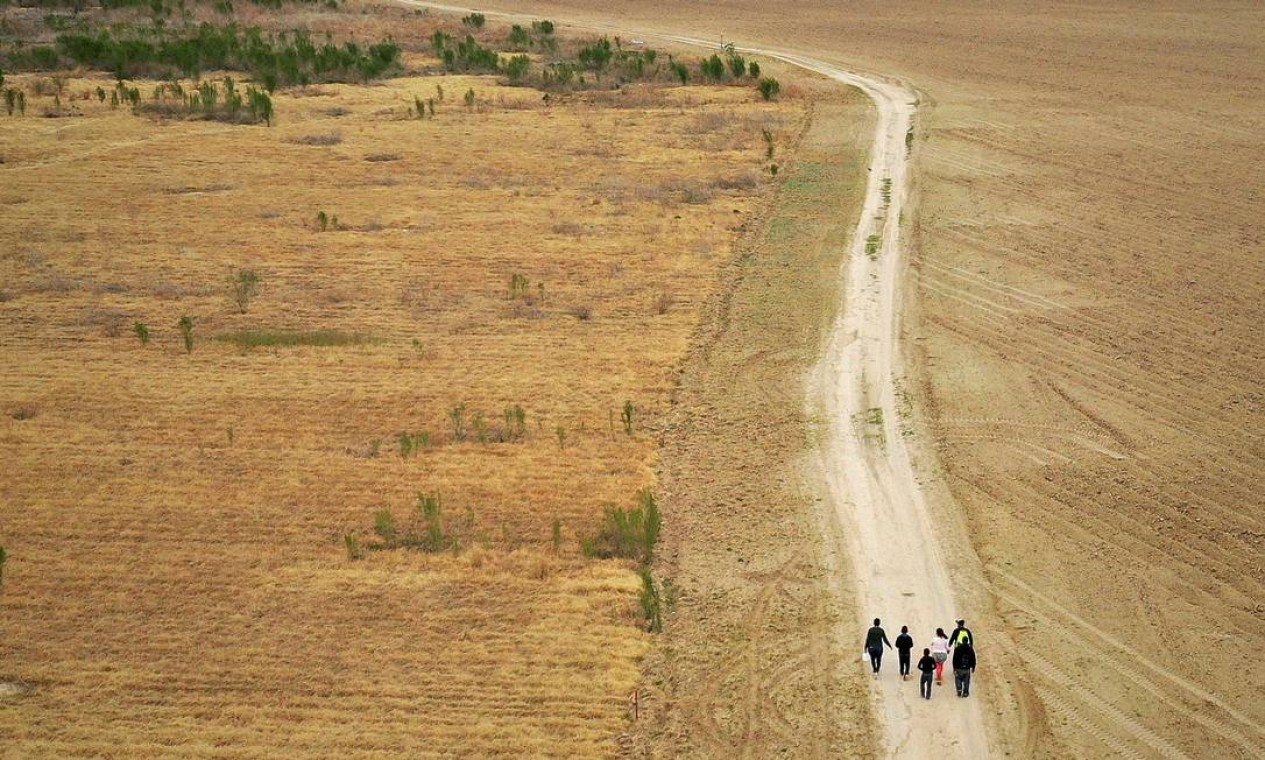 Famílias de migrantes em busca de asilo de Honduras e Guatemala caminham por uma estrada de terra depois de cruzar ilegalmente o Rio Grande para os EUA vindo do México, em Penitas, Texas Foto: Adrees Latif / REUTERS - 10/01/2019