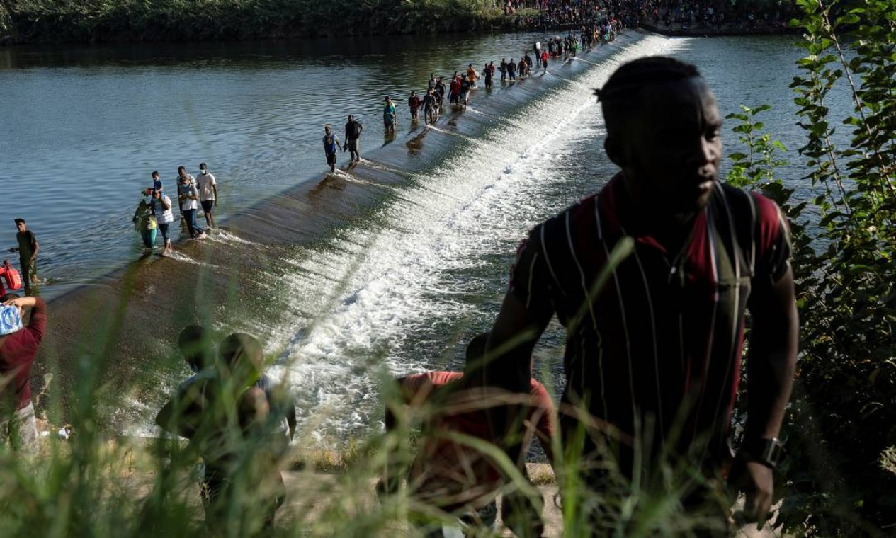 Imigrantes que buscam asilo nos EUA caminham no Rio Grande perto da Ponte Internacional entre o México e os EUA enquanto esperam para ser processados em Ciudad Acuña, no México. De acordo com autoridades, alguns imigrantes cruzam de um lado para outro do México para comprar comida e suprimentos Foto: GO NAKAMURA / REUTERS - 16/09/2021