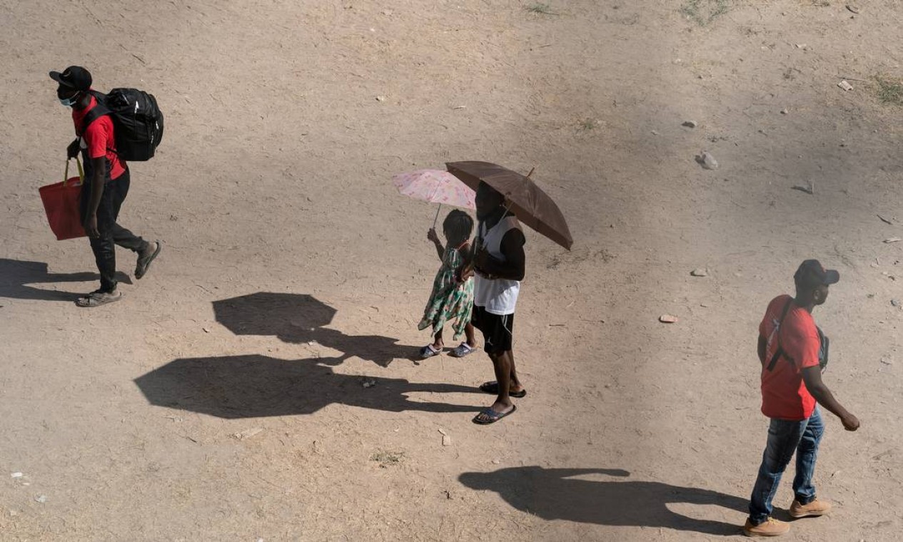 Imigrantes em busca de asilo caminham sob a Ponte Internacional entre México e EUA Foto: GO NAKAMURA / REUTERS