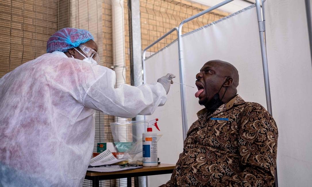 Em meio ao crescimento de casos de Covid-19 após descoberta da Ômicron, profissional de saúde faz teste PCR em um homem em Joanesburgo, na África do Sul. Foto: EMMANUEL CROSET / AFP