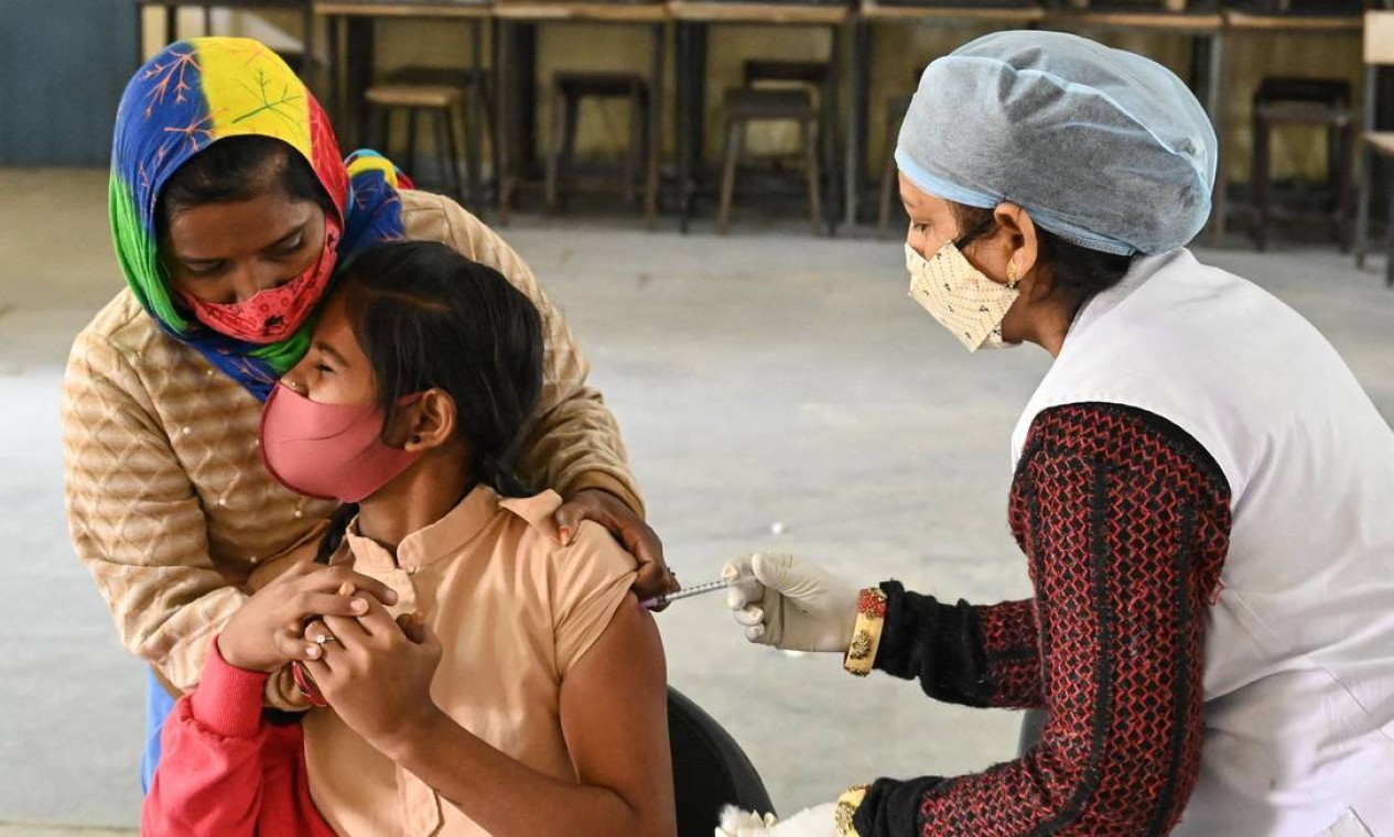 Estudante recebe dose da vacina contra o Covid-19 durante uma campanha de vacinação para pessoas entre 15 e 18 anos, em uma escola de Ajmer, na Índia Foto: SHAUKAT AHMED / AFP