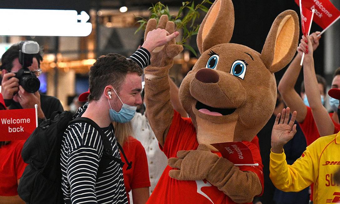 Um mascote dá as boas-vindas aos passageiros que chegaram no Aeroporto Internacional de Sydney, apósa Austrália reabrir as fronteiras para viajantes Foto: SAEED KHAN / AFP