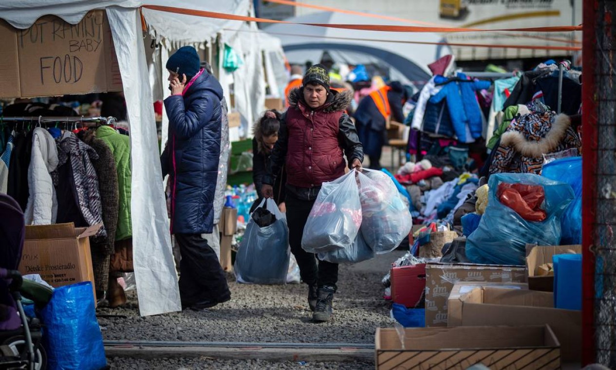 Roupas e alimentos são oferecidos a mulheres e crianças ucranianas que cruzam a fronteira eslovaca-ucraniana para deixar seu país em Vysne Nemecke, leste da Eslováquia Foto: PETER LAZAR / AFP