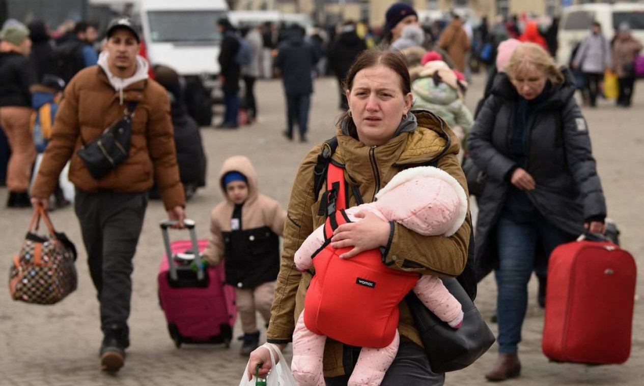 Evacuados do leste da Ucrânia são vistos do lado de fora da estação ferroviária na cidade de Lviv, no oeste da Ucrânia Foto: YURIY DYACHYSHYN / AFP