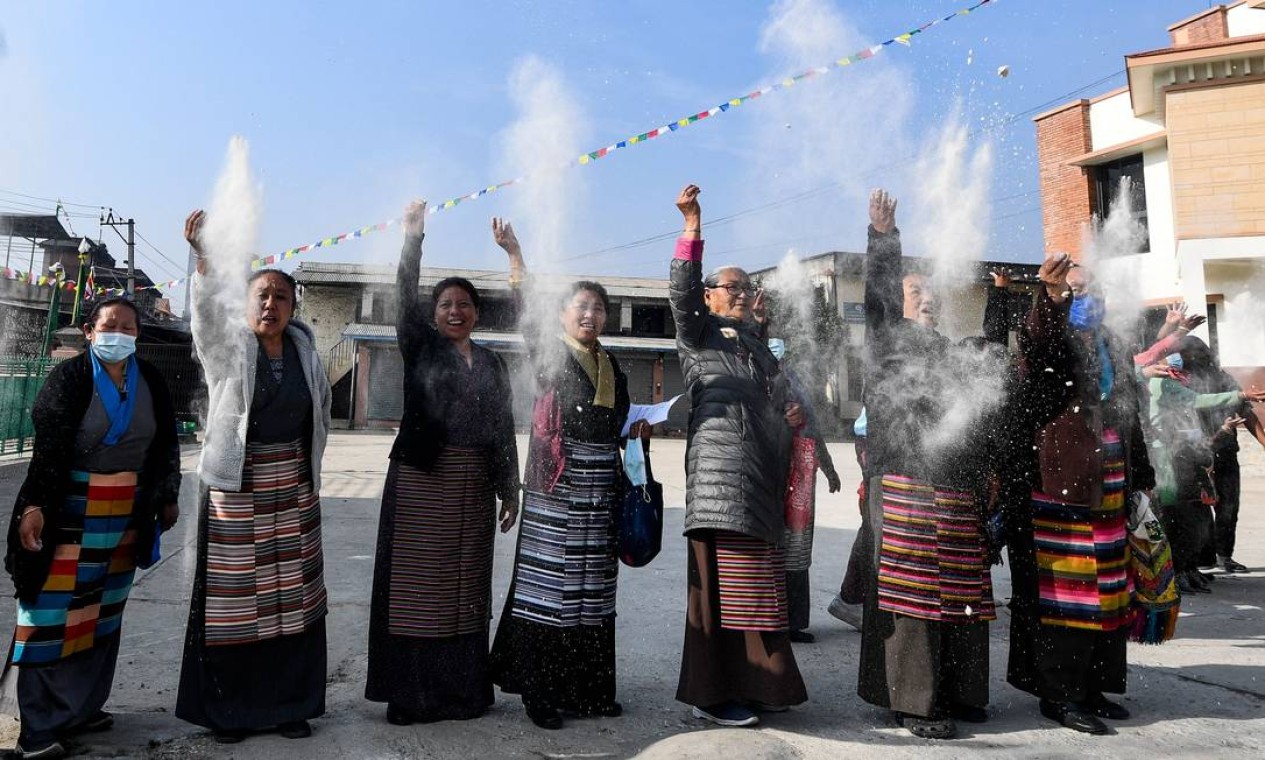 Exilados tibetanos jogam farinha no ar durante um ritual que marca o 63º aniversário da revolta tibetana de 1959 contra o domínio chinês, no campo tibetano de Jawalakhel, em Lalitpur, nos arredores de Katmandu Foto: PRAKASH MATHEMA / AFP