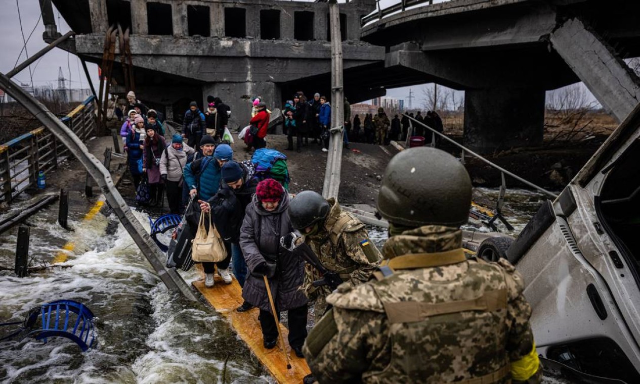 Idosa atravessa ponte destruída em Irpin para fugir da guerra Foto: DIMITAR DILKOFF / AFP