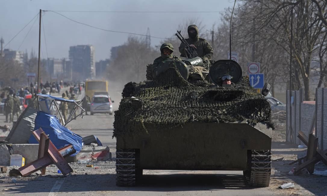 Membros do serviço de tropas pró-Rússia em uniformes sem insígnia dirigem um veículo blindado na cidade portuária de Mariupol Foto: Reuters