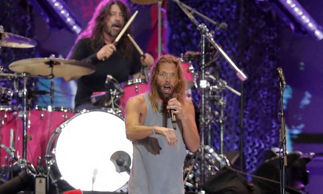 Foto de 18 de março, com o baterista Taylor Hawkins (no vocal) e Dave Grohl trocando de função no Lollapalooza 2022 em Santiago Foto: Javier Torres / AFP