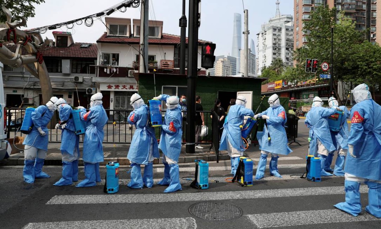 Trabalhadores em trajes de proteção se preparam para desinfetar complexo residencial no distrito de Huangpu, após surto de Covid-19, em Xangai, China Foto: CHINA DAILY / VIA REUTERS