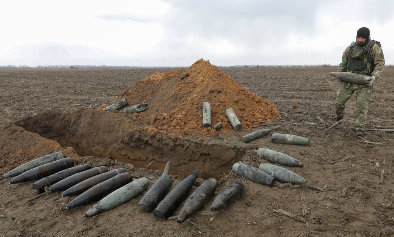 Militar carrega um projétil não detonado perto da vila de Motyzhyn Foto: STRINGER / REUTERS