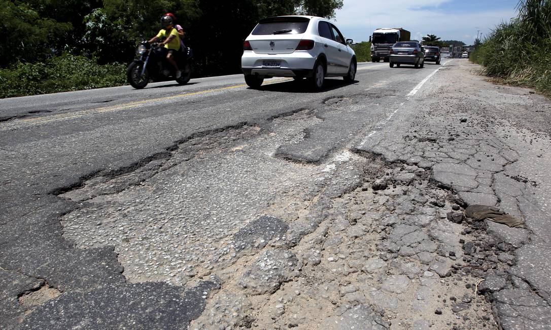 Rodovia esburacada no Rio. Ministério da Infraestrutura diz que faltam recursos para recuperação e construção de estradas Foto: Custódio Coimbra / Arquivo / Agência O Globo