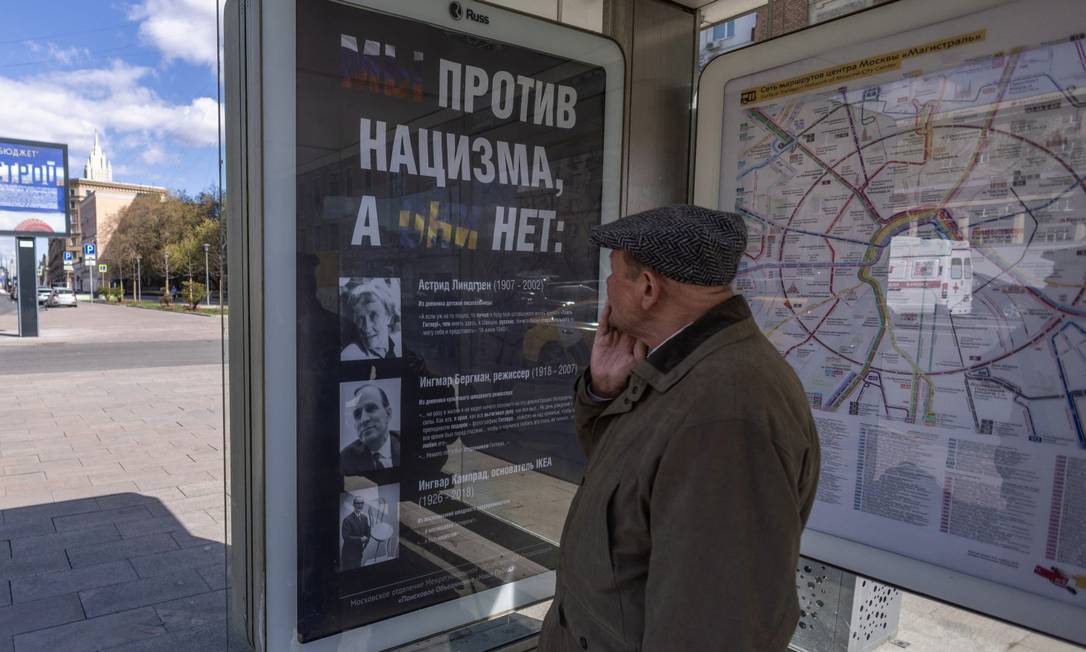 Homem observa cartaz com fotos da escritora sueca Astrid Lindgren, do cineasta Ingmar Bergman, do fundador da IKEA, Ingvar Kamprad, e a mensagem: "Nós somos contra o nazimso, eles não" Foto: REUTERS PHOTOGRAPHER / REUTERS