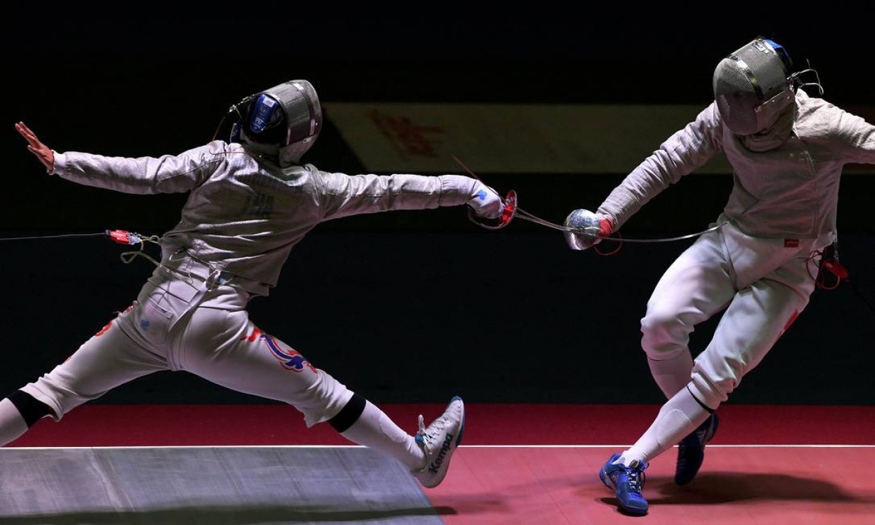 O tailandês Panachai Wiriyatangsakul compete contra o vietnamita Vu Thanh An durante o evento de esgrima masculino na 31º edição dos Jogos do Sudeste Asiático, em Hanói Foto: TANG CHHIN SOTHY / AFP