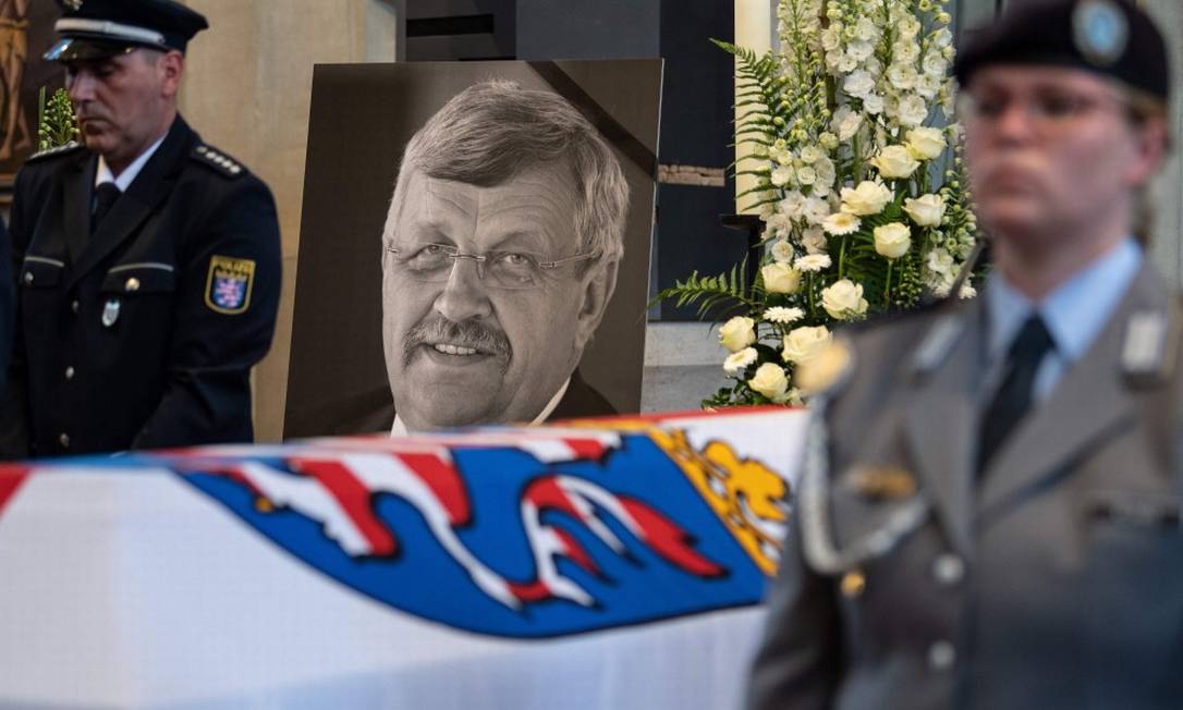 Um retrato de Walter Lübcke, líder do conselho regional de Kassel assassinado no começo de junho, ao lado de seu caixão Foto: SWEN PFORTNER / AFP
