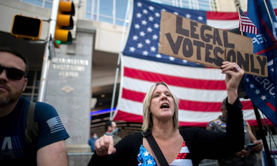 Carri Dusza, uma apoiadora de Donald Trump, segura um cartaz onde se lê "apenas votos legais", em frente a um centro de contagem na Pensilvânia, um dos estados com maior número de processos por parte do presidente Foto: MARK MAKELA / REUTERS