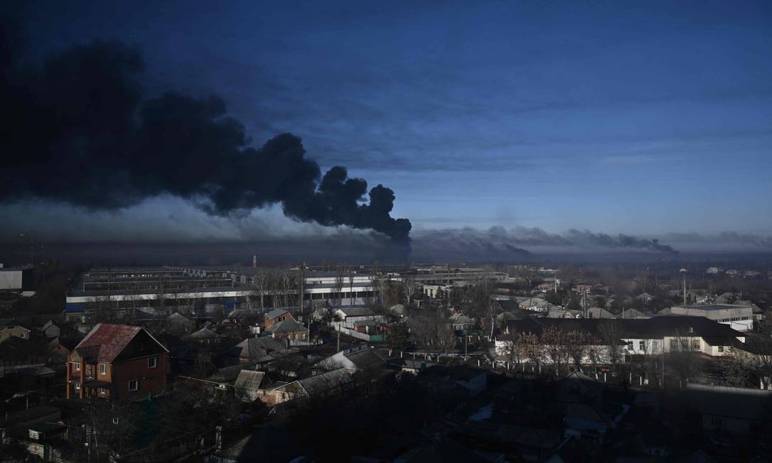 Fumaça preta sobe de um aeroporto militar em Chuguyev, perto de Kharkiv, na Ucrânia Foto: ARIS MESSINIS / AFP