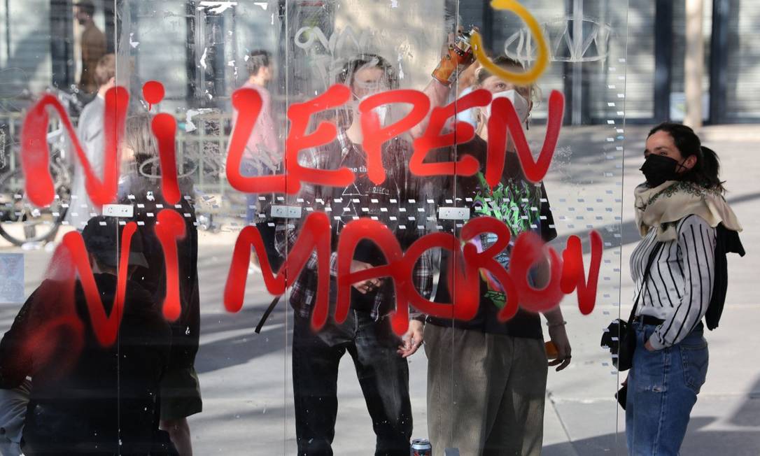 Manifestantes em Nantes em frente a uma pichação onde se lê "Nem Le Pen, nem Macron" Foto: THOMAS COEX / AFP