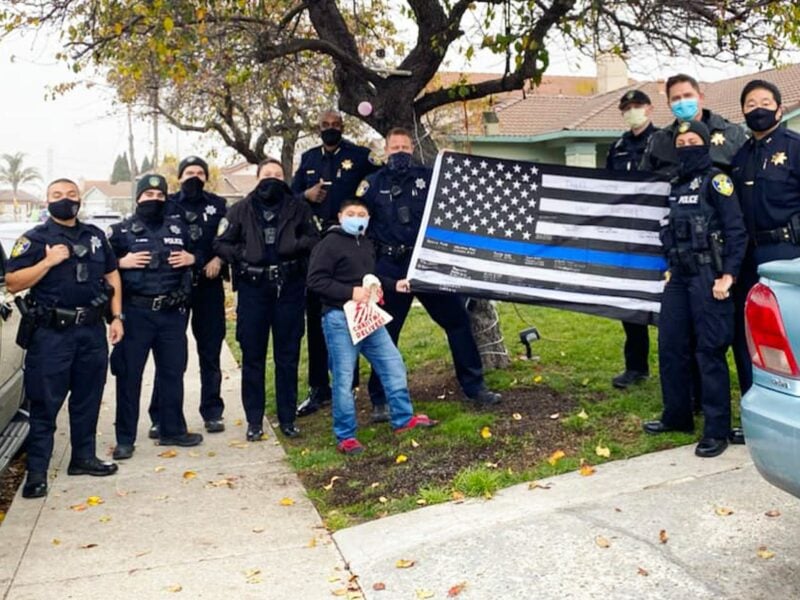 Members of the Vallejo Police Department, including Chief Shawny Williams, Deputy Chief Michael Kihmm, and Captain Jason Potts pose for a photograph with the controversial "Blue Lives Matter" flag, which has been criticized for its associations with the white supremacist movement. The Vallejo Police Department posted the image to its official social media accounts on Dec. 25, 2020, but deleted it from Twitter following criticism. The photograph remains on the department’s official Facebook and Instagram pages.