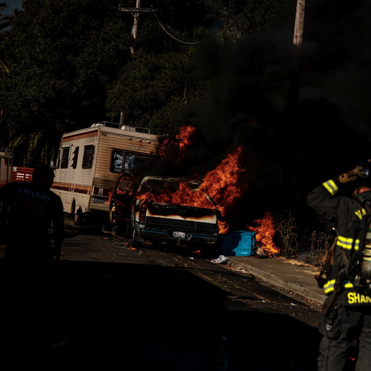 In pictures: Firefighters, neighbors stop vehicle fire that threatened homes