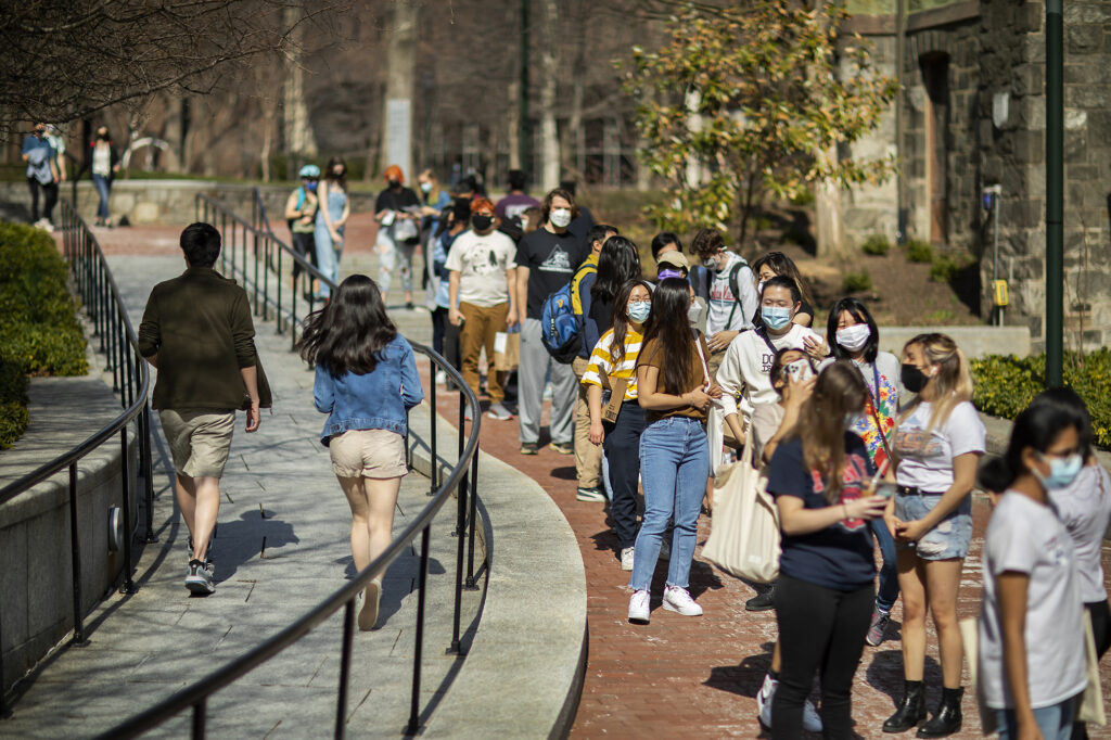 Students masked and waiting in line outside