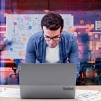 A young man working on his Lenovo laptop in the office