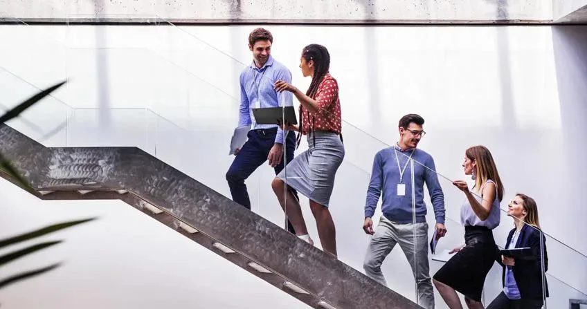 Five colleagues ascending a staircase 