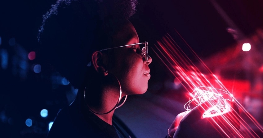 A person holding a string of lights that is shining red light onto her face