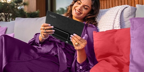 Womand holding a Lenovo Tablet while smiling and sitting relaxed