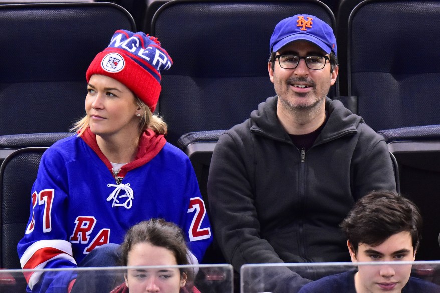 John Oliver and wife Kate Norley attend the New York Rangers game at Madison Square Garden on Tuesday.