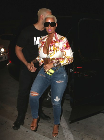 Amber Rose arrives at Catch restaurant wearing ripped denim, bright print silk blouse and dark sunglasses