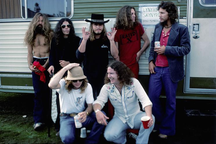 CALIFORNIA - OCTOBER 1976: Southern Rock band Lynyrd Skynyrd (L-R back row Artimus Pyle, Gary Rossington, Ronnie Van Zant, Allen Collins and Steve Gaines, front row Leon Wilkeson and Billy Powell) pose by their trailer backstage at an outdoor concert in October, 1976 in California. (Photo by Michael Ochs Archives/Getty Images)