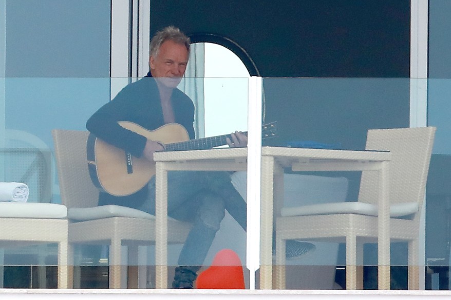 Sting strums his guitar on the balcony of his Cannes hotel.