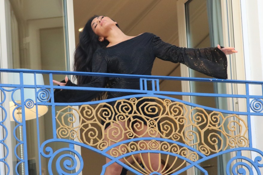 Nicole Scherzinger dramatically tosses her hair with open arms on her balcony in Cannes.