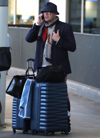 Billy Zane looks distressed as he waits at the airport while on the phone.