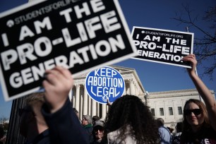 Pro-life activists try to block the sign of a pro-choice activist during the 2018 March for Life January 19, 2018.