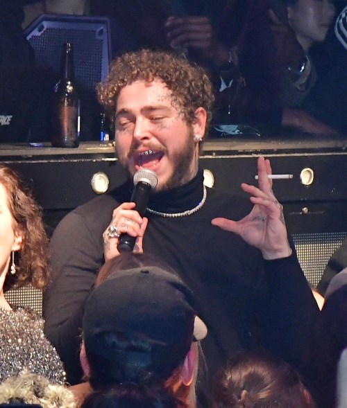 Post Malone ignores the law as he smokes a cigarette indoors at Marquee in New York.