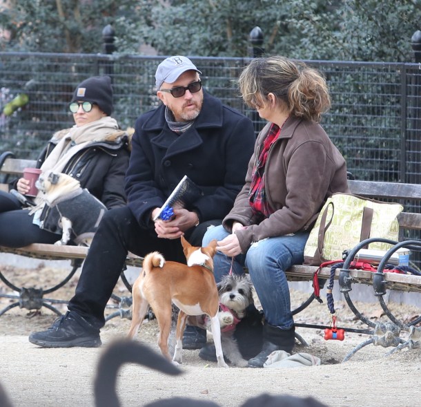 Louis C.K. chats with a female friend, after receiving a present from her, at the dog park in New York.